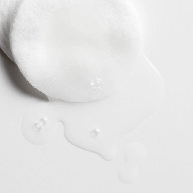 Close-up of a cotton pad soaked with Blithe Anti-Polluaging Cleansing Water, illustrating its gentle yet effective cleansing action on sensitive skin.