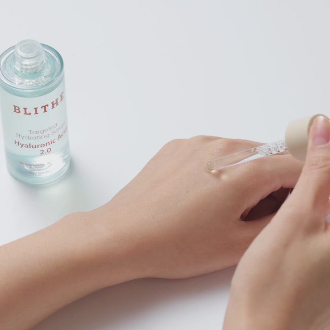 Hand applying BLITHE Targeted Hydrating Serum Hyaluronic Acid 2.0, demonstrating its deep moisturizing and hydrating effects on the skin.